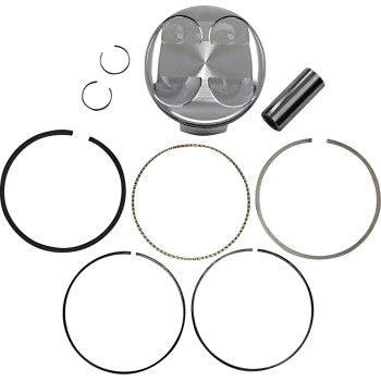 Silver metal piston with rounded top, accompanied by various black and metallic piston rings and two small circular clips on