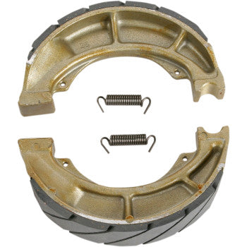 Two semi-circular metallic Ebc Brake Shoes with black bonded linings and two small coiled metal springs are placed between them on a white background.