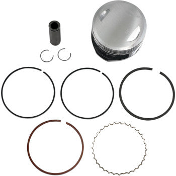 Silver metal piston with black base, black wrist pin, two small circlips, and five assorted piston rings arranged below on.
