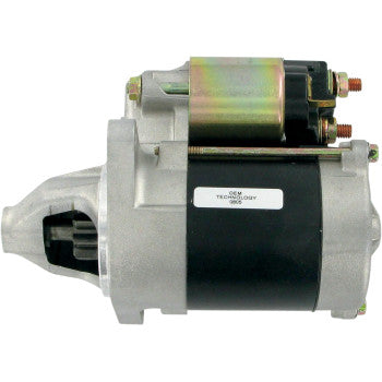 The Kawasaki Starter Motor by Rick's Motorsport Electric features a cylindrical black and silver body, copper terminals, top-mounted solenoid, longer-life bearings, and a visible starter gear on the left side.