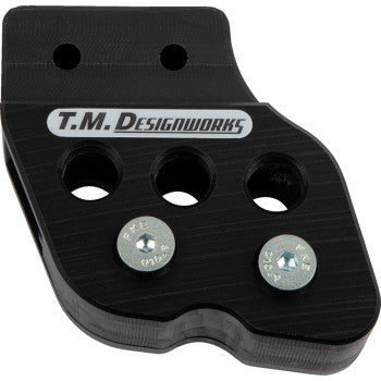 The Honda - Yamaha - Kawasaki - Suzuki Chain Guide Black by T.M. Designworks features three large holes, two visible mounting screws, silver and black branding, plus built-in UV protection for long-lasting durability.