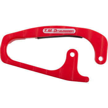 The Honda Front Chain Slider Red by T.M. Designworks is durably made from composite materials, features a curved red design with the T.M. Designworks logo, and offers an open section plus a mounting hole for easy installation.