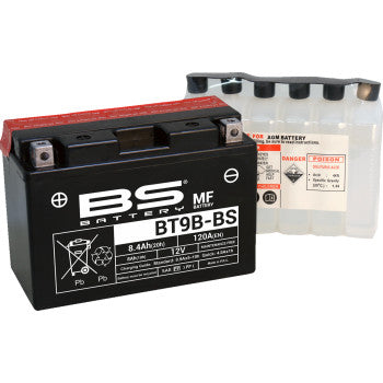 A Battery BT9B BS (YT) by Bs Battery, black and 12V sealed maintenance-free, is shown beside a clear plastic acid pack for filling; both display product labels and warning signs.