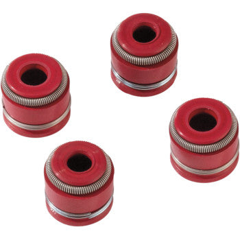 Four red Viton valve stem seals with metal springs from the Suzuki Valve Seal Kit Suzuki LTR by Moose Offroad, arranged diagonally on a white background, offer improved sealing for intake and exhaust valves.