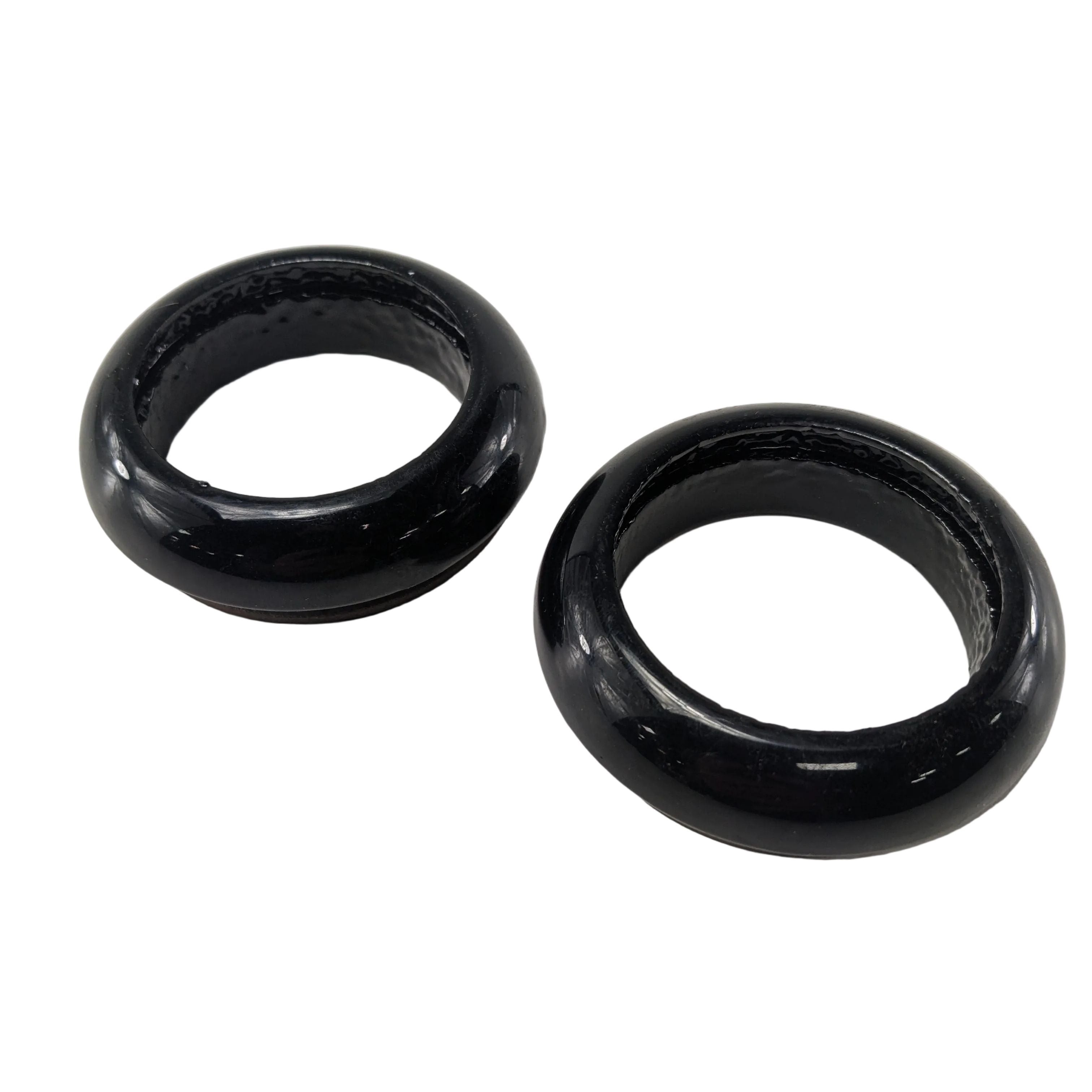 Two black circular fork caps and dust seals with smooth, glossy finish designed for motorcycle forks.