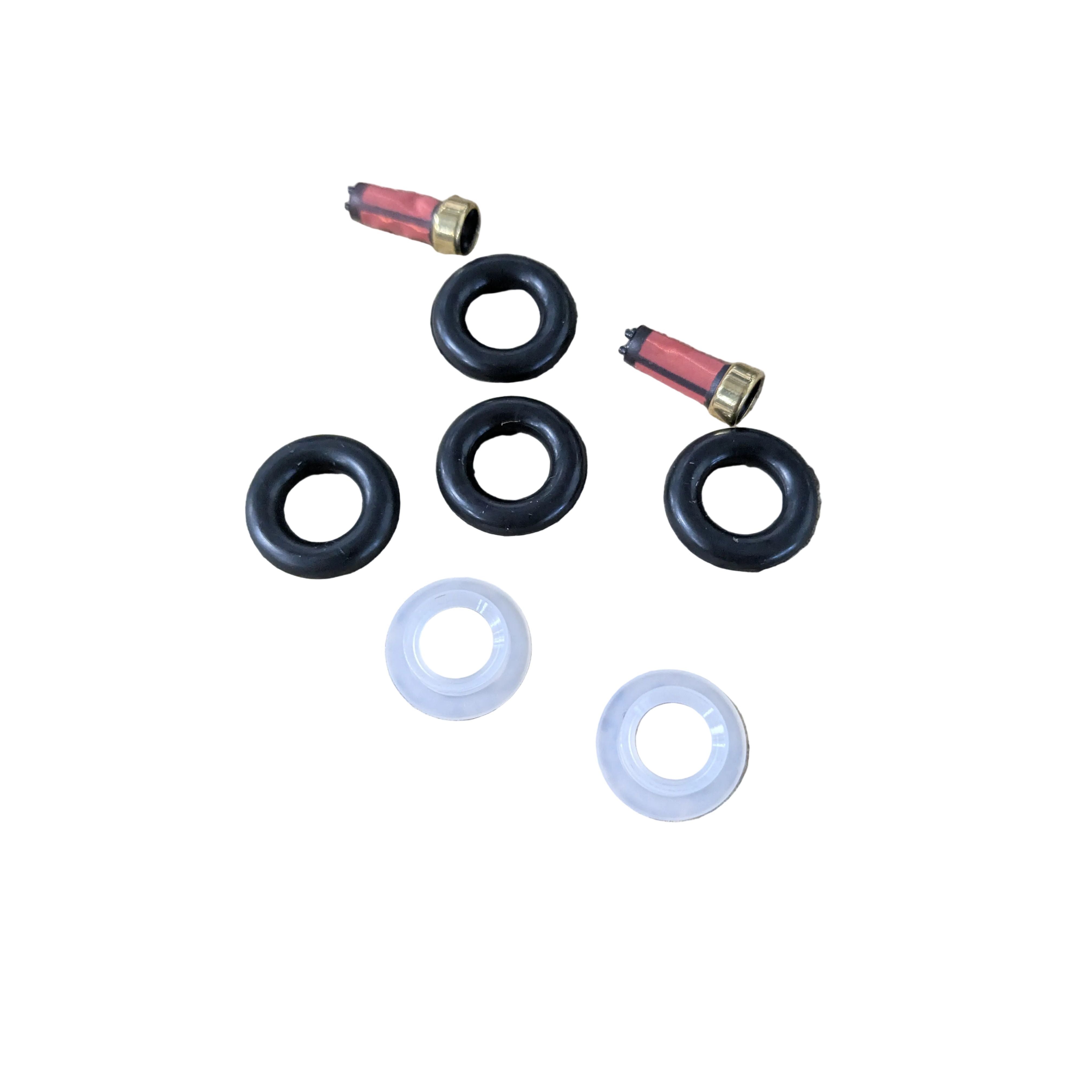Fuel injector rebuild kit with two brass and red injector filters, three black rubber O-rings, and two white plastic spacers.