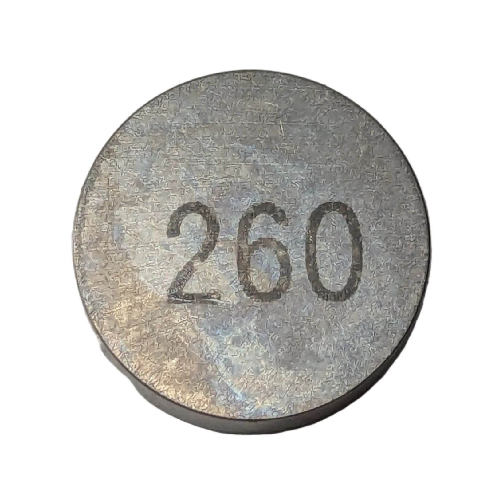 Round metallic shim with "260" engraved on top, smooth silver finish.