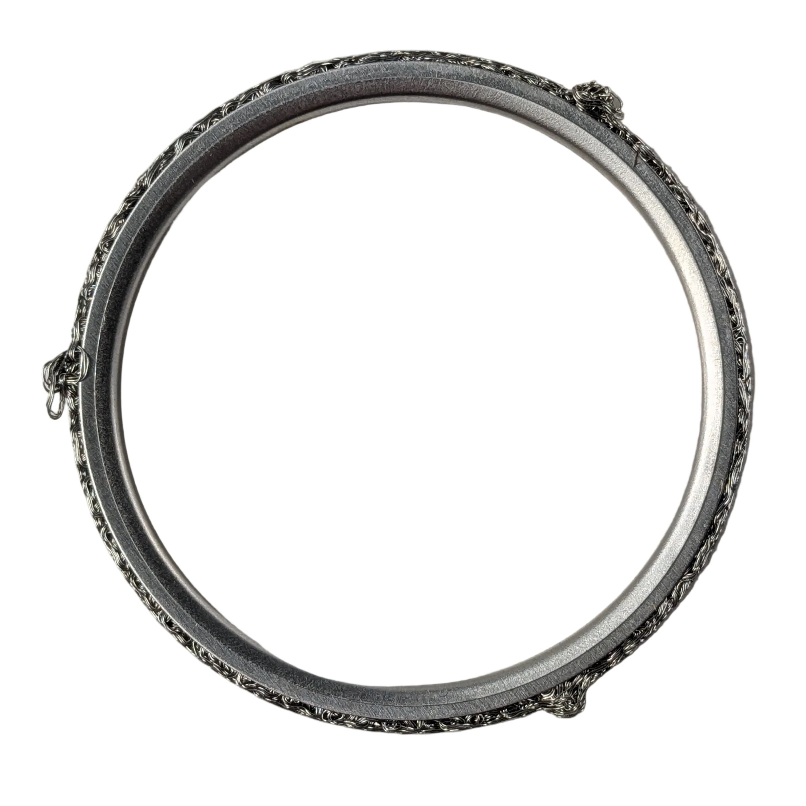 Metal circular exhaust gasket ring with textured outer surface and smooth inner edge.