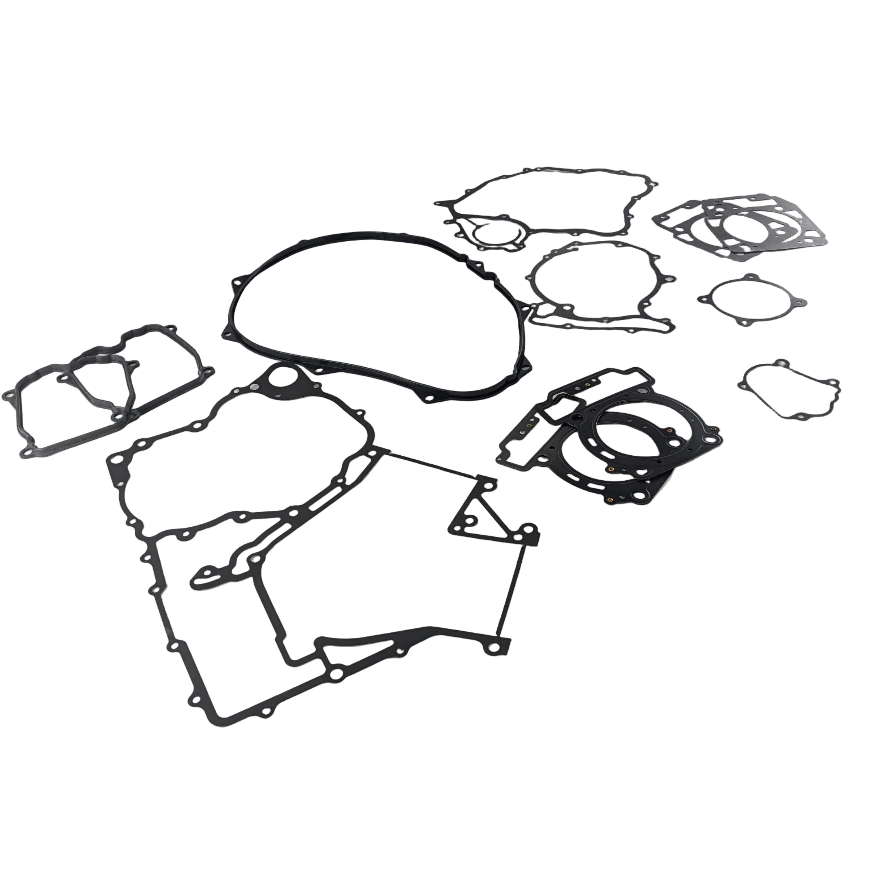 Black rubber engine gasket kit with multiple irregular and circular shapes laid out on a white surface.