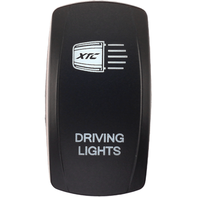 A black rectangular Dash Switch Rocker Face for driving lights by XTC Power features a white light icon with the XTC brand inside and DRIVING LIGHTS text below.