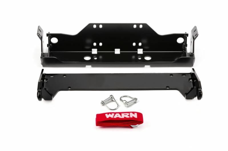 The Yamaha SXS ATV Front Snow Plow Mounting Kit by Warn includes a black powder-coated metal winch plate, two brackets, two silver D-shackles, and a red WARN strap for corrosion resistance—all shown on a white background.
