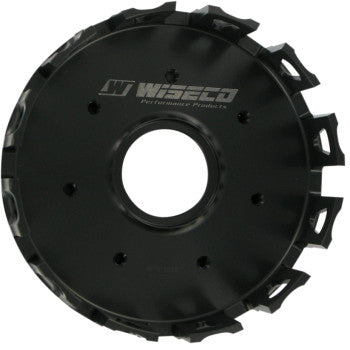The Clutch Basket by Wiseco is a black, circular component made from aerospace-grade aluminum alloy, featuring gear-like outer edges and a central hole, with the Wiseco Performance Products logo.