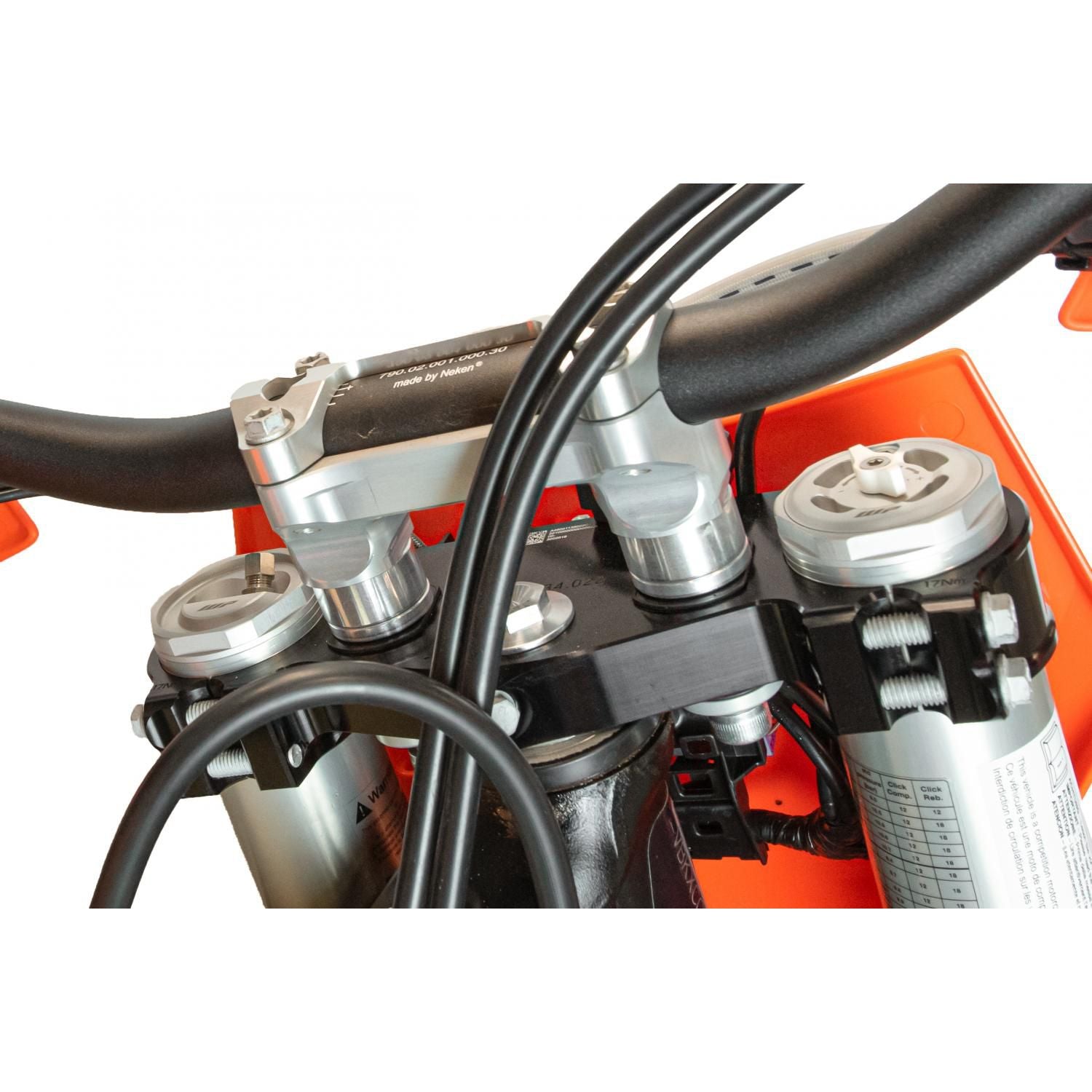 Close-up of a motorcycle handlebar area near the orange fairing—an ideal spot to keep the lightweight Trail Tool by Enduro Engineering handy. Handlebars, clamps, fork tubes, and cables are shown, all set against a white background.