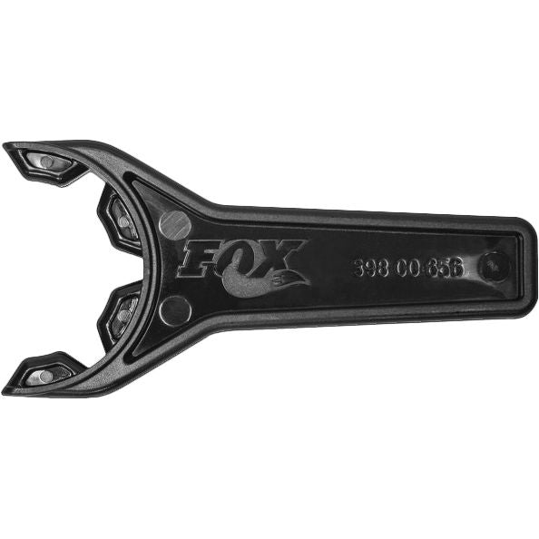 The Shock Preload Wrench by Fox is a black plastic tool with a unique three-pronged open end, designed for adjusting shock preload. It features part number 398-00-856 embossed on the handle.