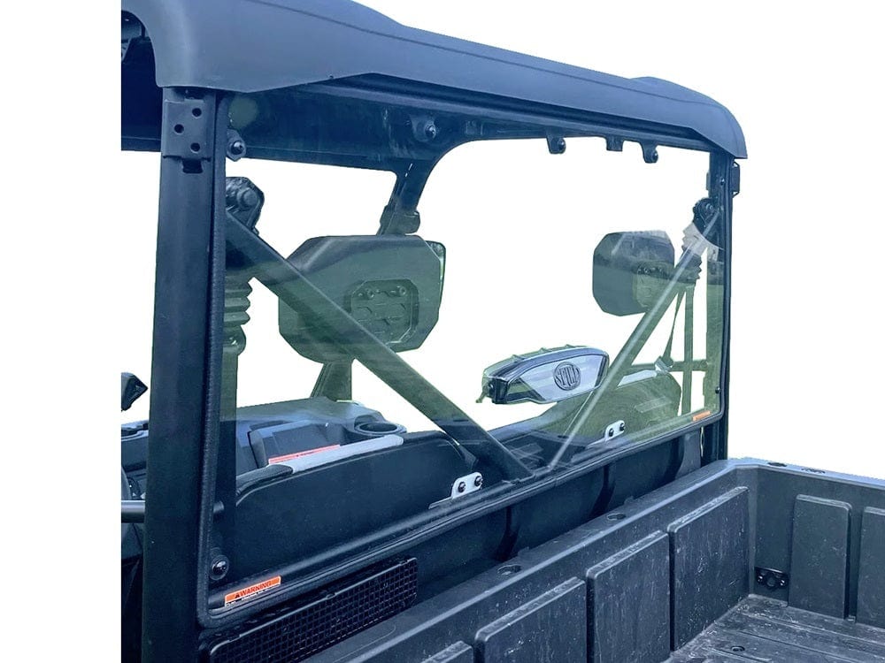 A CFMOTO U-Force 600 (2022+) Vented Tinted Rear Windshield by Spike is installed on a utility vehicle, framed by a black roll cage and secured with metal brackets. Seats and headrests are visible inside, enhancing your off-road experience.