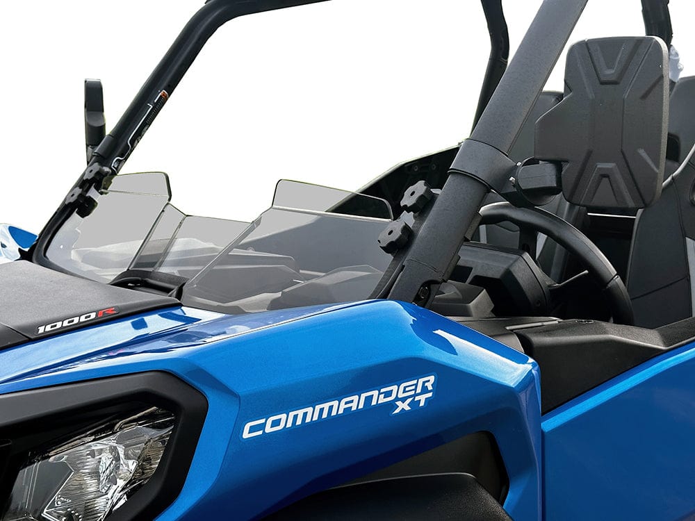 Close-up of a blue Can-Am Commander with the Stealth Tinted Hard Coated Short Windshield by Spike, showing the windshield, steering wheel, and front seat to highlight protection and visibility on off-road adventures.