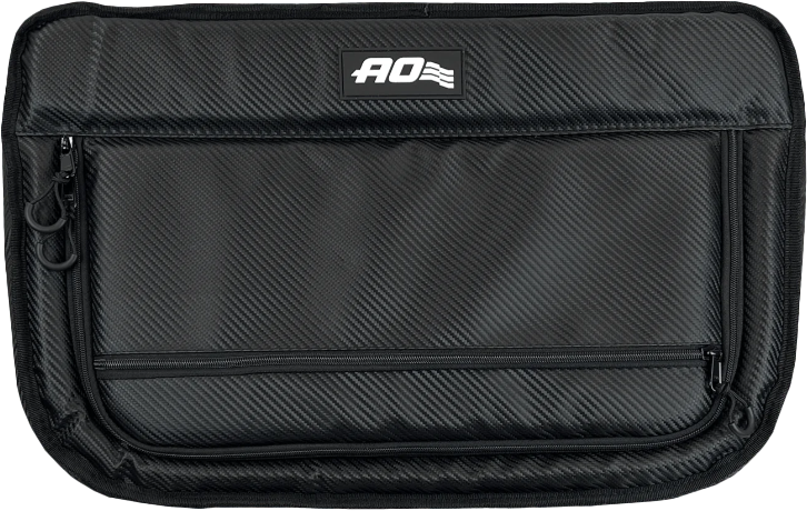 The AO Coolers 38 Pack Capacity Carbon Stow-N-Go Black Cooler is a rectangular, soft-sided, insulated bag with a textured finish, front zipper pocket, and AO logo plus small flag at the top center.