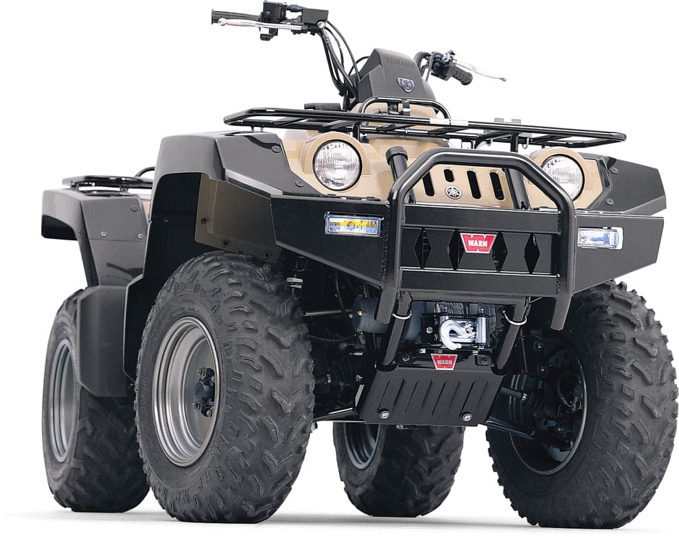 The Polaris Ranger ATV Front Bumper Winch Mounting Kit by Warn is shown from a low front angle on a rugged ATV with large, deep-tread tires, front bumper guard, and powder-coated accents in black and tan for enhanced durability.
