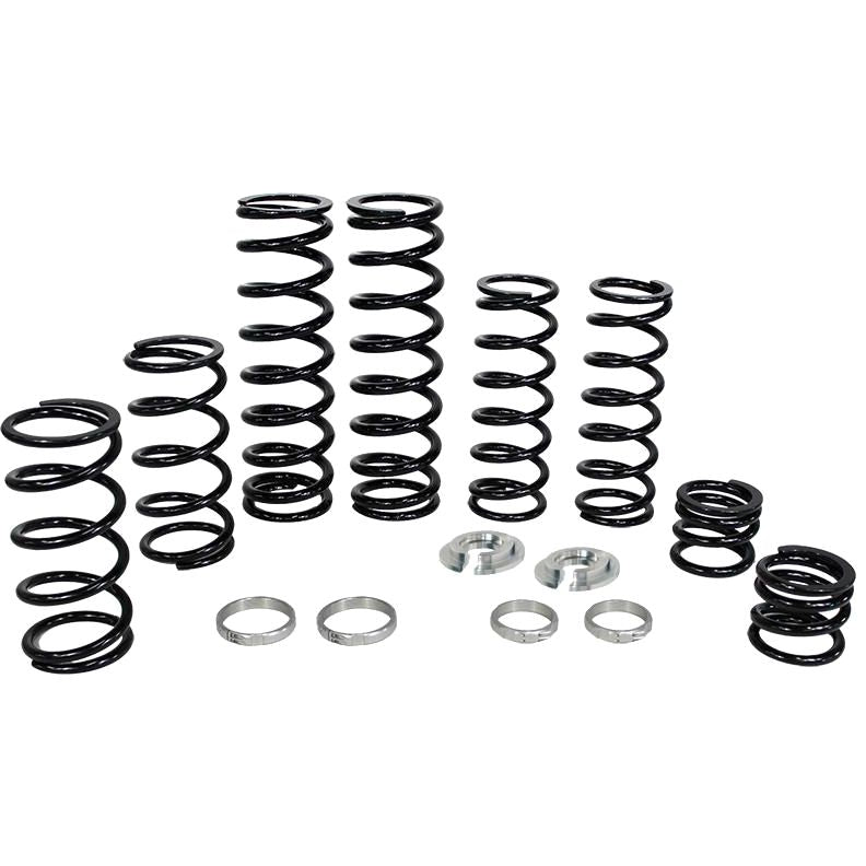 The Polaris Dual Rate Spring Kit by ZBroz includes black metal coil springs of various sizes, four silver rings, and two circular components, all arranged in a row on a white background for enhanced bottoming resistance.