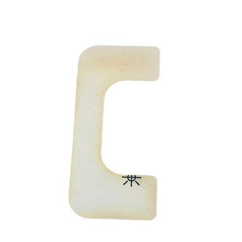 A beige plastic "C"-shaped object with a black double circle symbol, identified as Label-Manual,2/4Wd by Kawasaki, commonly used as an OEM Kawasaki off-road or ATV accessory, shown on a white background.