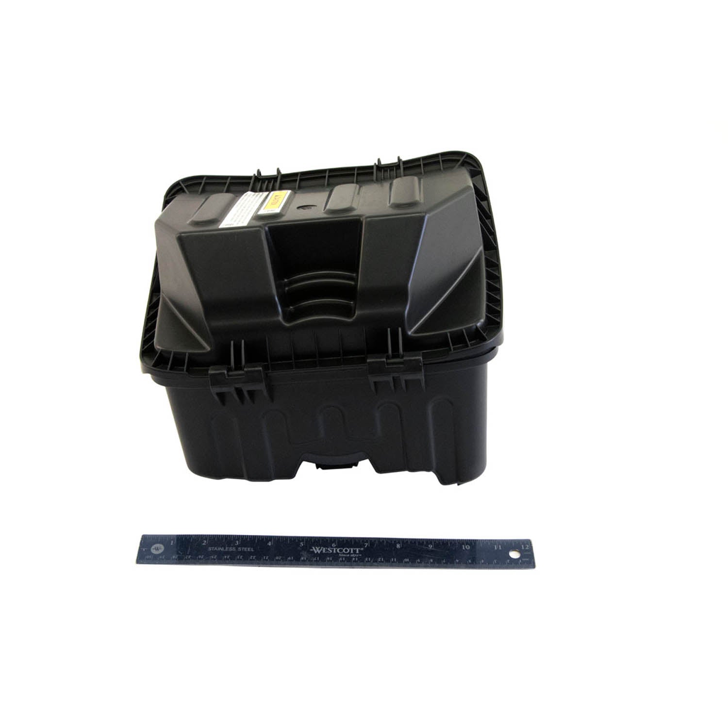 Black rectangular plastic airbox with vented top and ridged design, shown next to a blue ruler for scale.