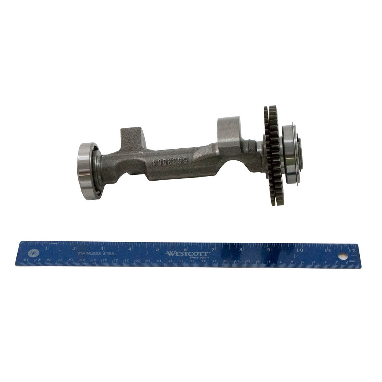 Metal balance shaft with gear teeth and splined end next to a blue 12-inch ruler.