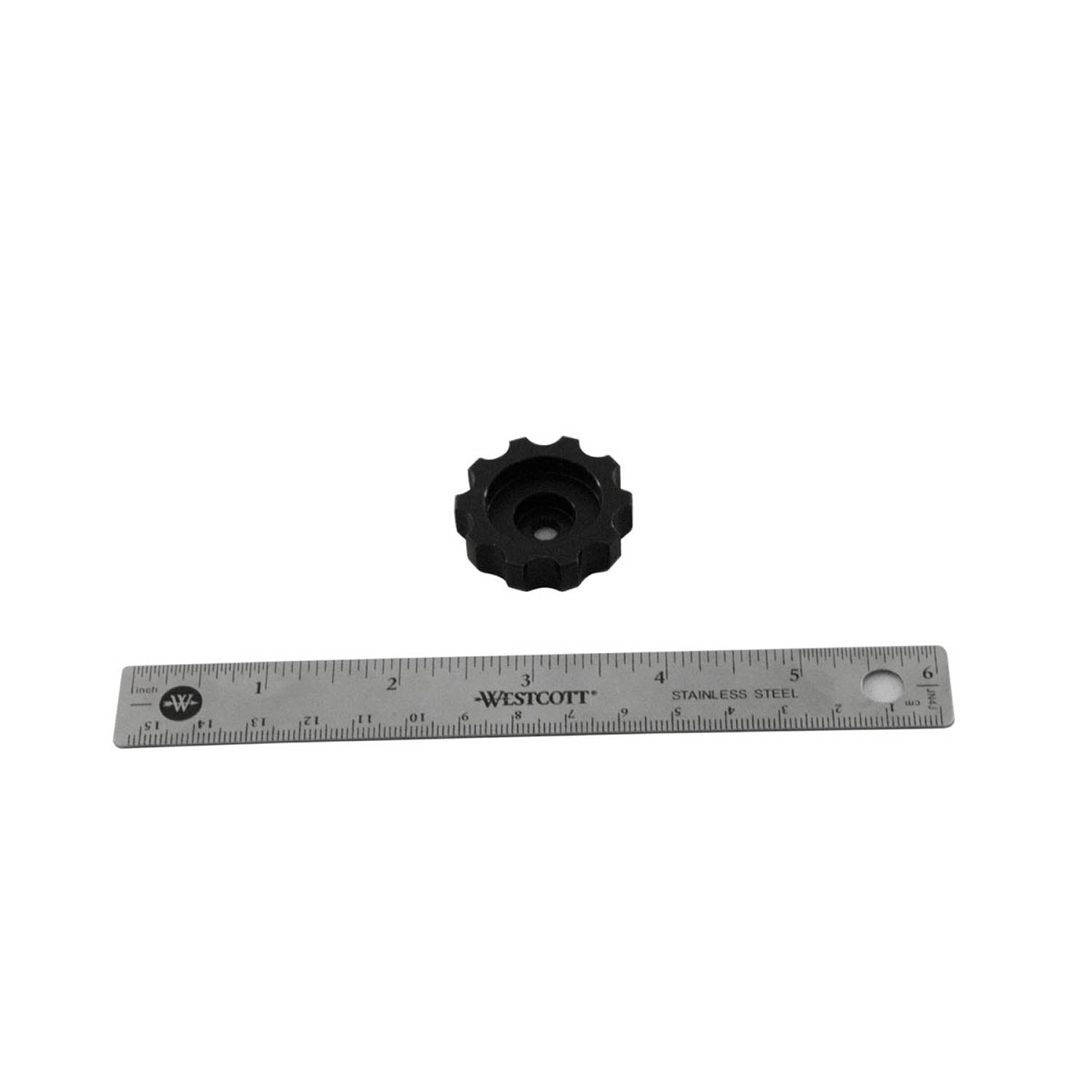 Black plastic adjuster knob with a gear-like edge, about 2 inches wide, next to a metal ruler for scale.