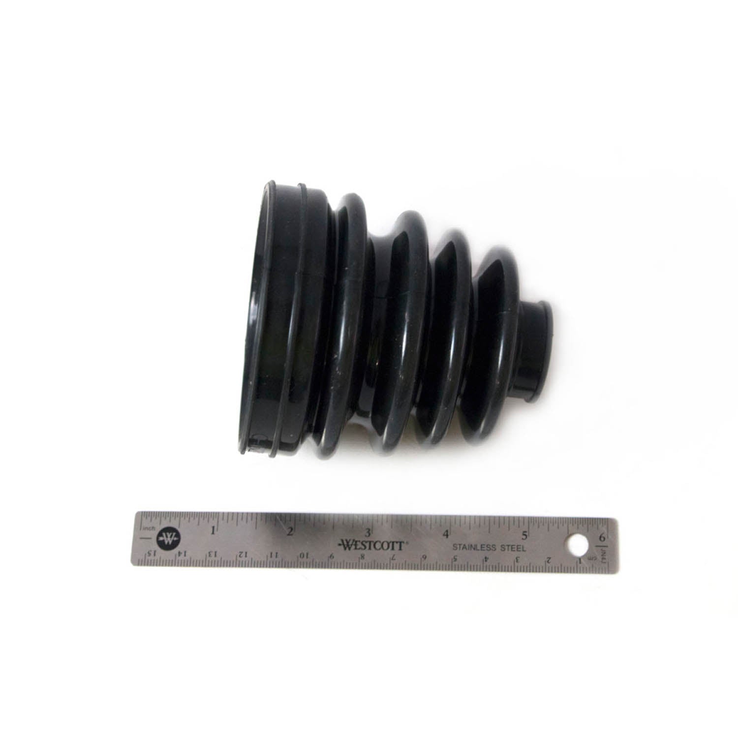 Black rubber CV boot with accordion pleats, shown next to a 6-inch metal ruler for scale.