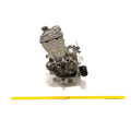 Silver metal long block engine kit with visible gears and components, placed upright next to a yellow measuring tape.