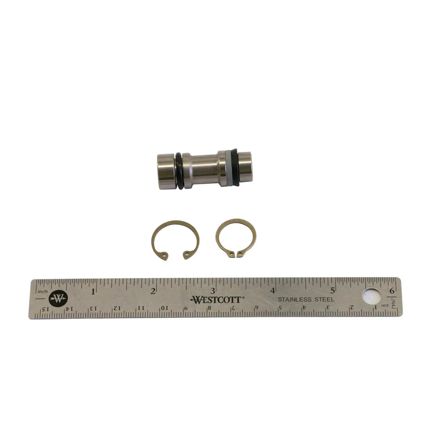 Metal piston with black O-rings and two circular retaining clips alongside a 6-inch ruler for scale.