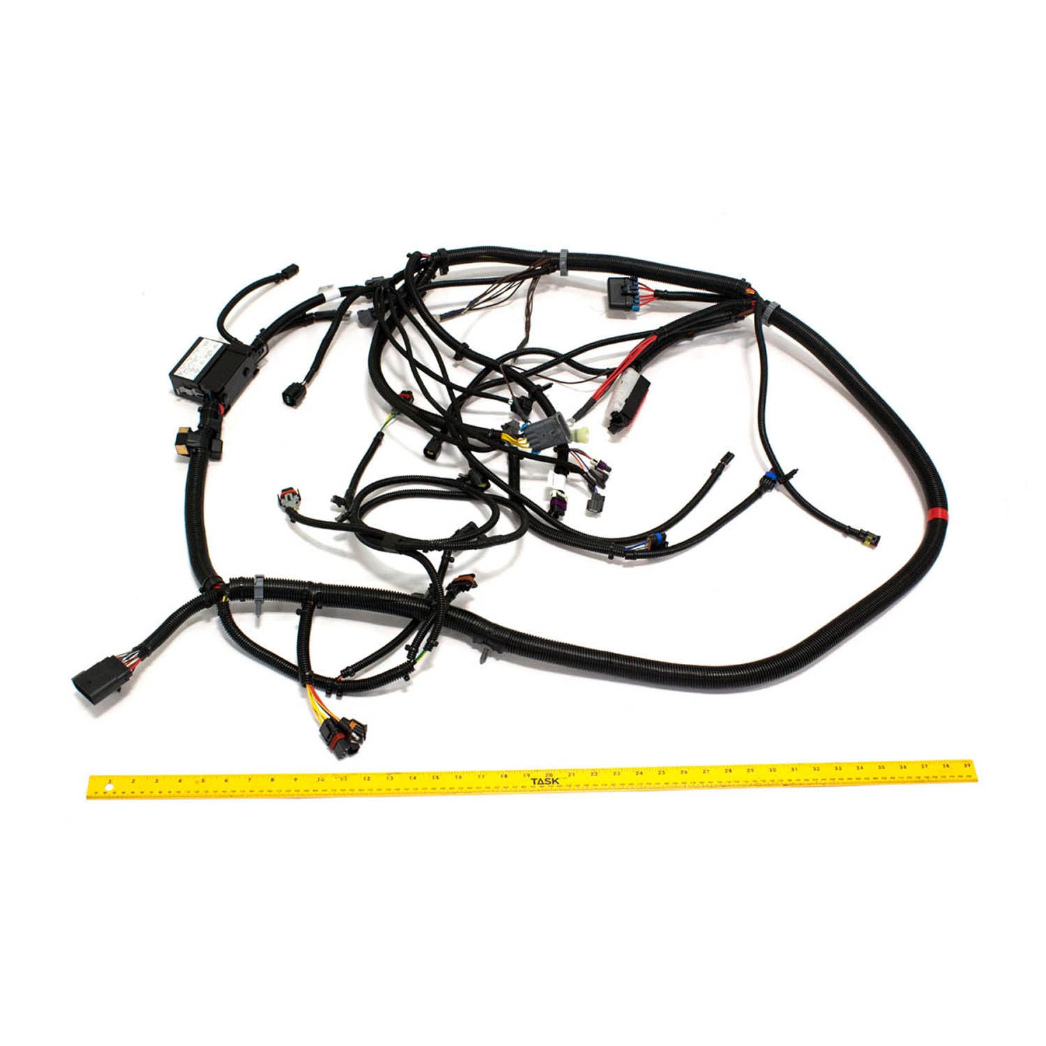 Black multi-connector wiring harness with bundled cables and connectors laid beside a yellow measuring tape.