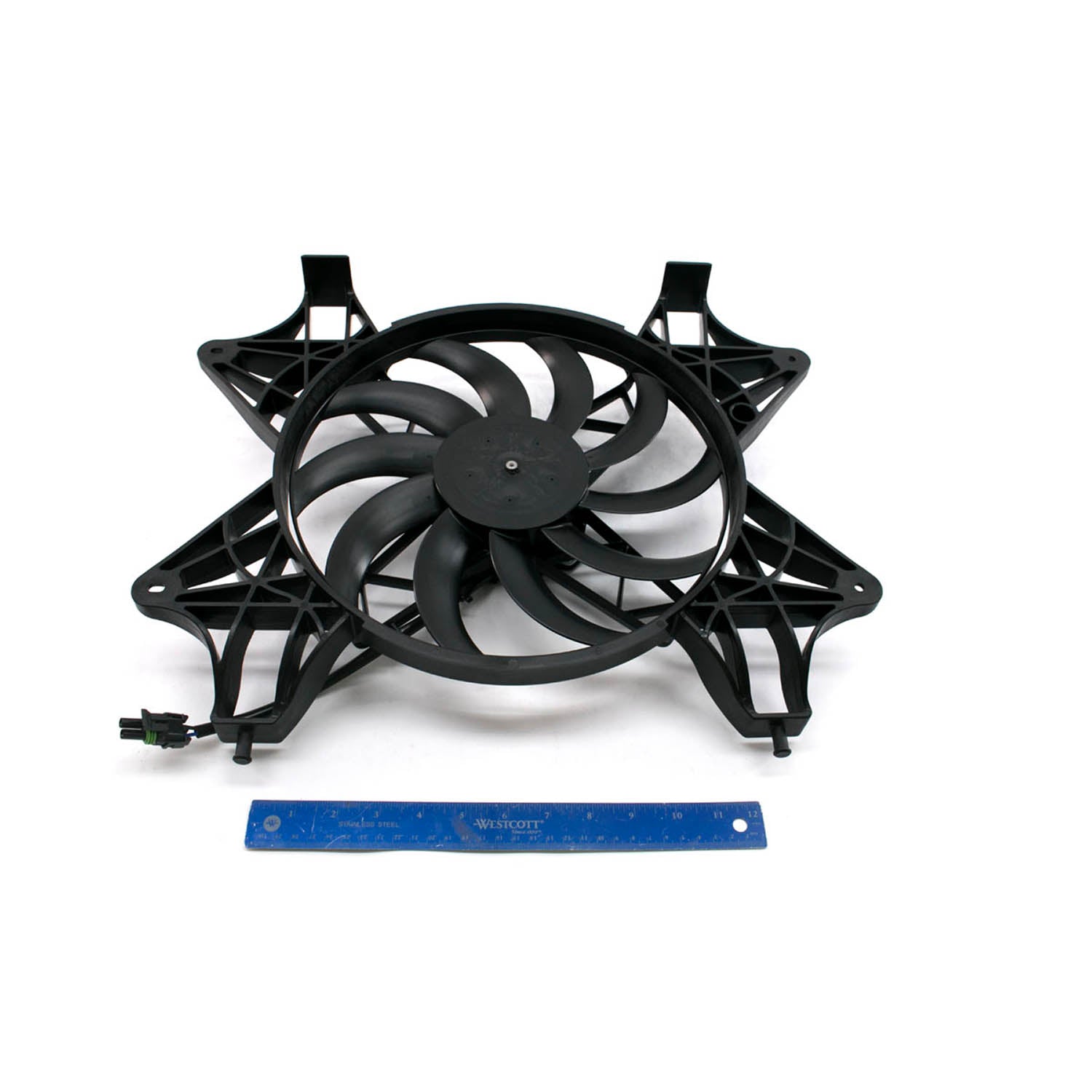 Black plastic cooling fan with nine curved blades and mounting frame, alongside blue ruler for scale.
