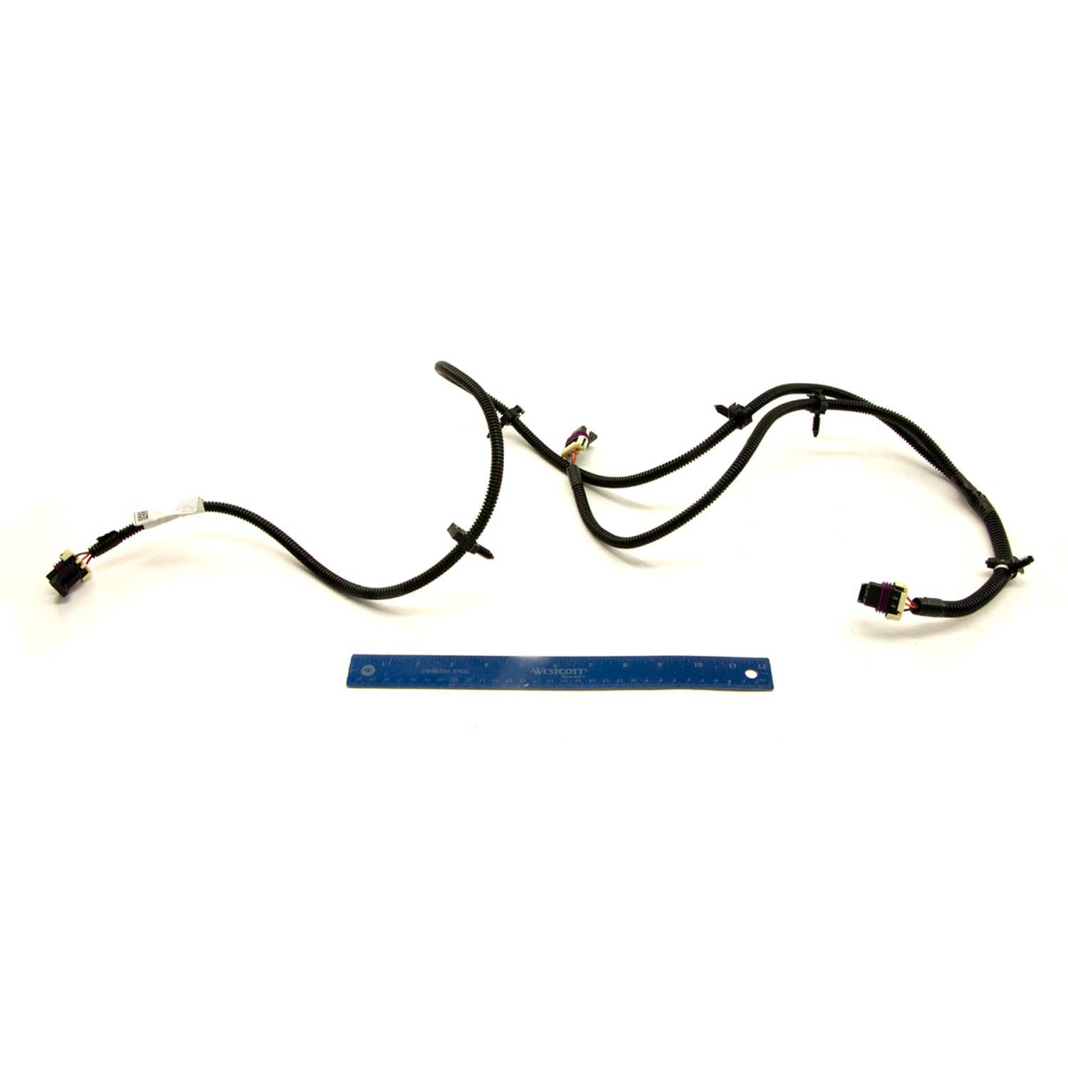 Black wired cargo box harness with connectors and clips, laid flat next to a blue ruler for scale.