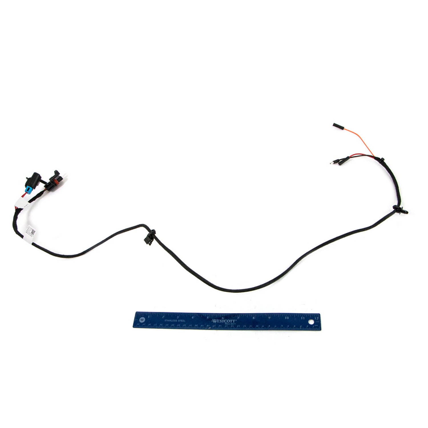 Black wiring harness with multiple connectors and a blue ruler for scale on white background.