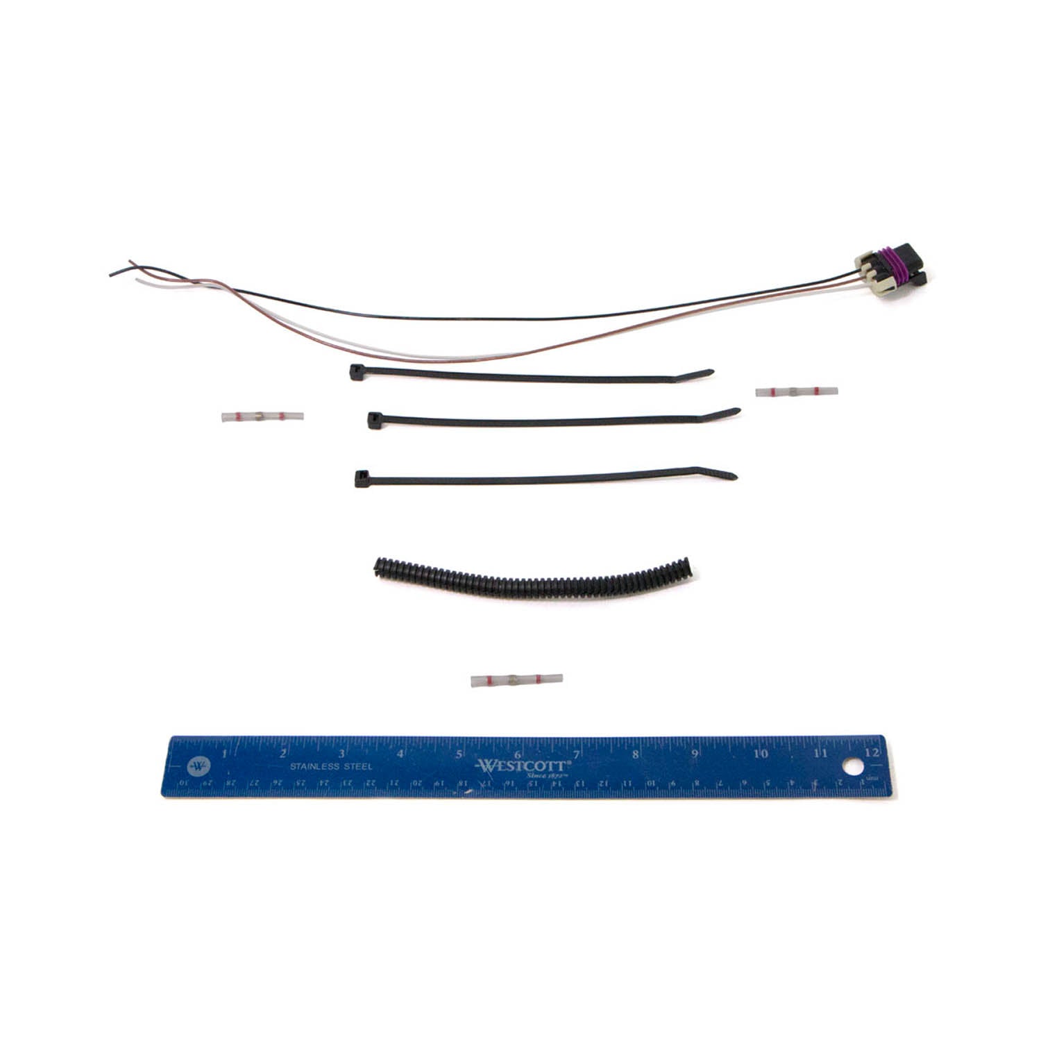 Black CPS harness kit with wiring connector, zip ties, and wiring tubing alongside a blue ruler for scale.