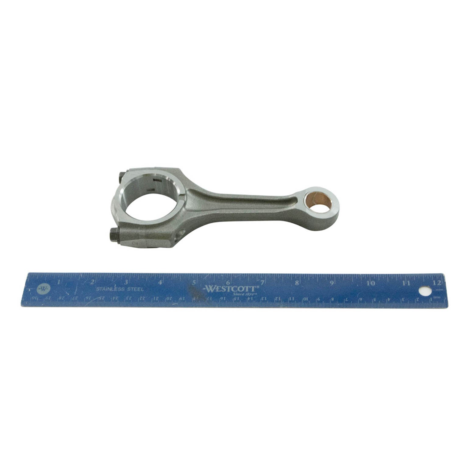 Silver metal connecting rod with circular ends, placed above a blue 12-inch ruler.