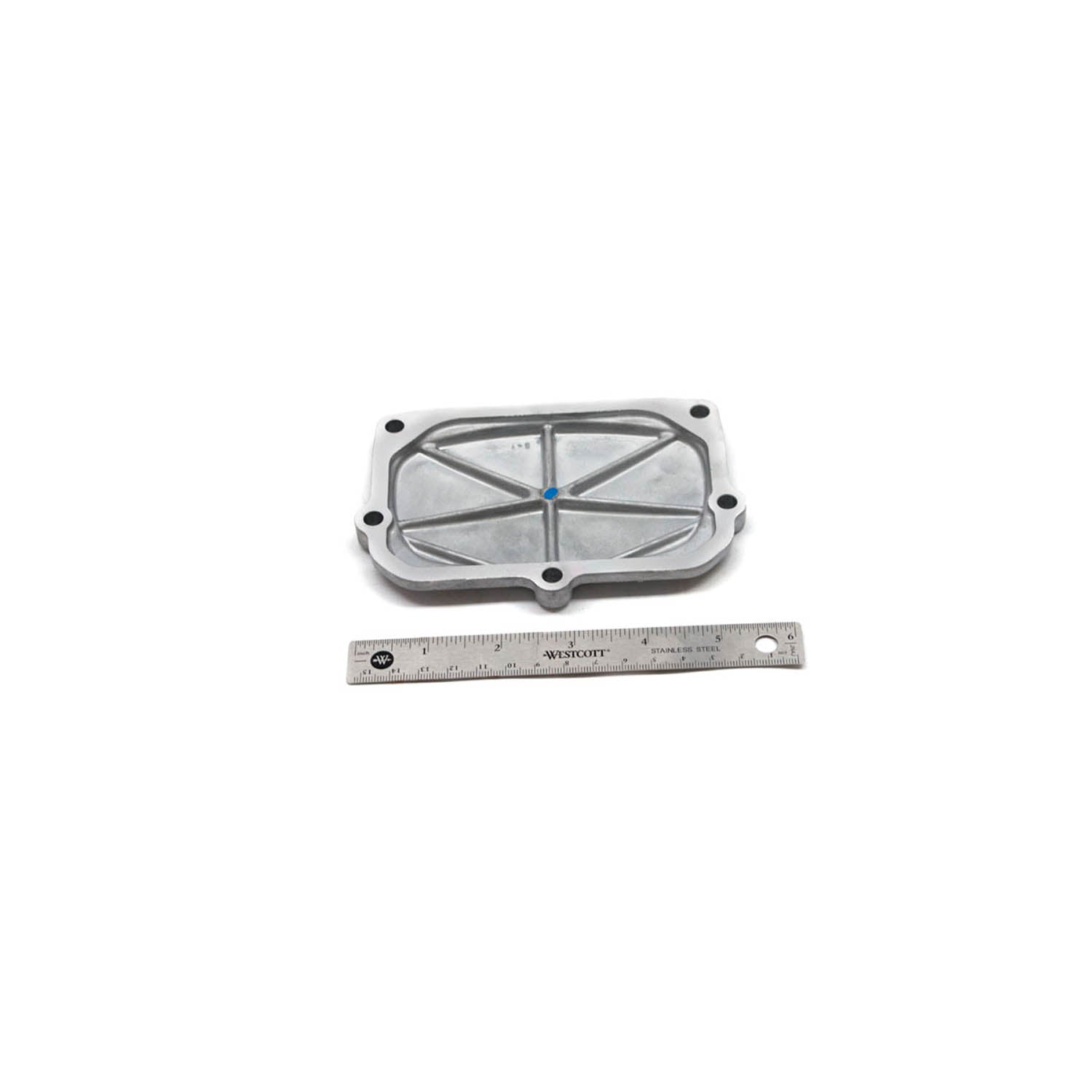 Silver metal camshaft cover with raised cross pattern and bolt holes, shown with ruler for scale.