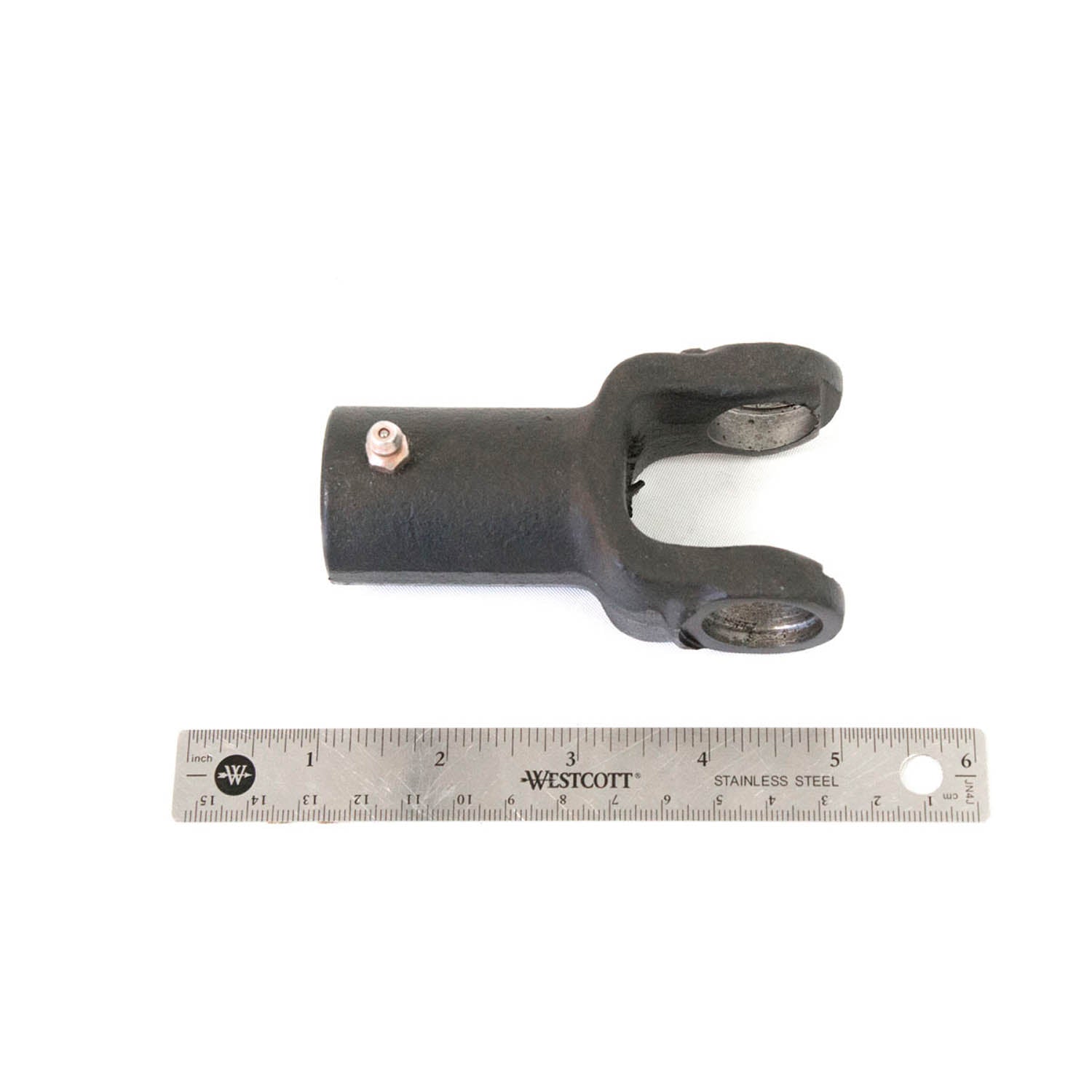 Black metal prop shaft yoke with forked end and machined holes, shown next to 6-inch ruler for scale.