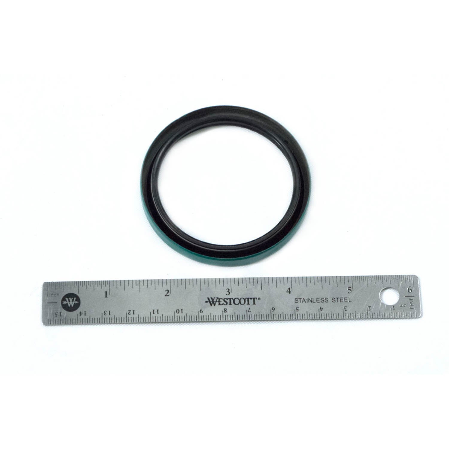 Black rubber circular hub strut seal next to silver metal ruler for size reference.