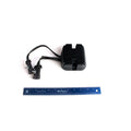 Compact black metal voltage rectifier/regulator with cooling fins and attached wiring harness with connectors next to a blue