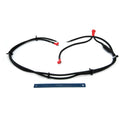 Black insulated battery ground cable with red terminal covers and secured connectors, laid flat next to a blue ruler for.