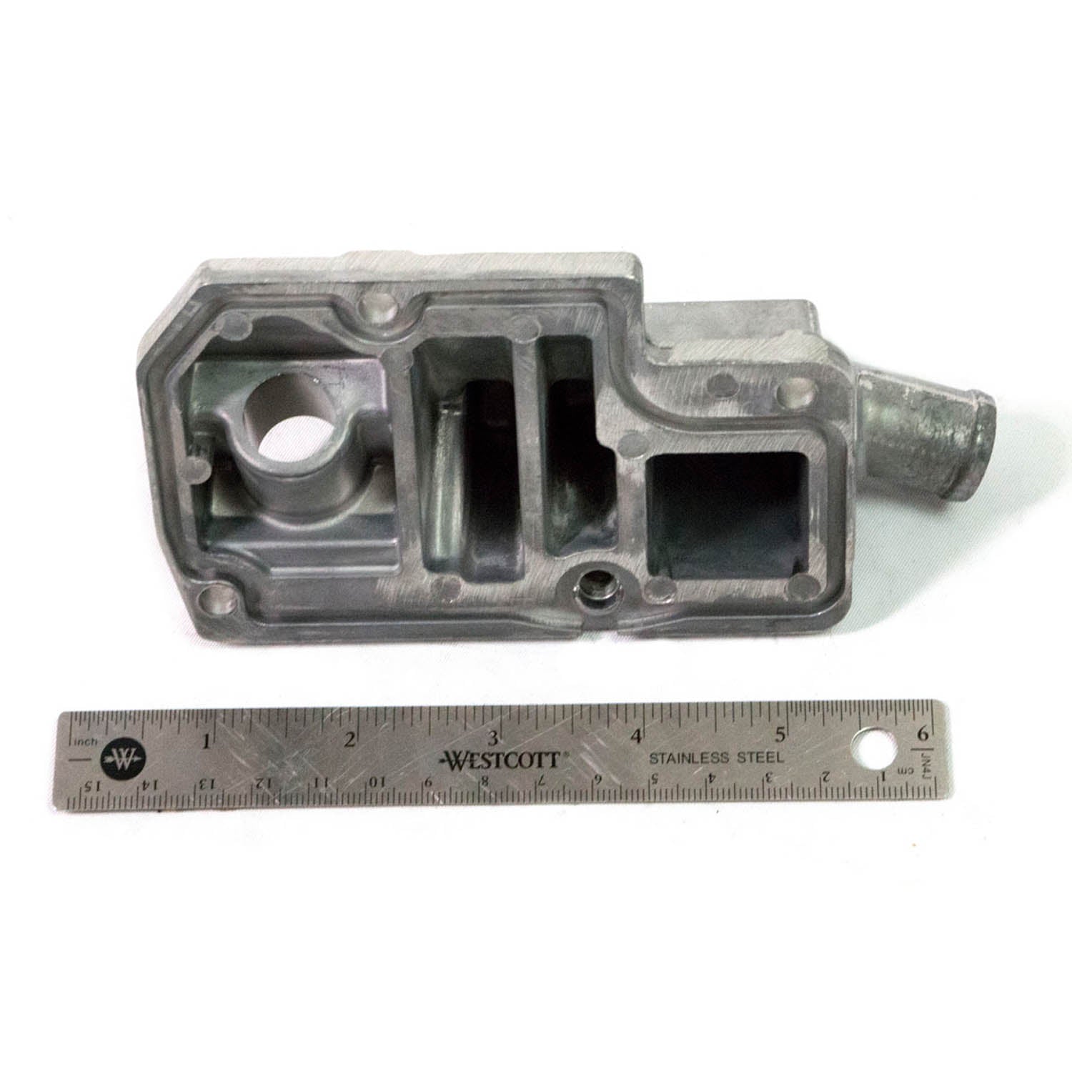 Gray metal breather cover with multiple compartments and a cylindrical outlet, shown next to a 6-inch ruler for scale.