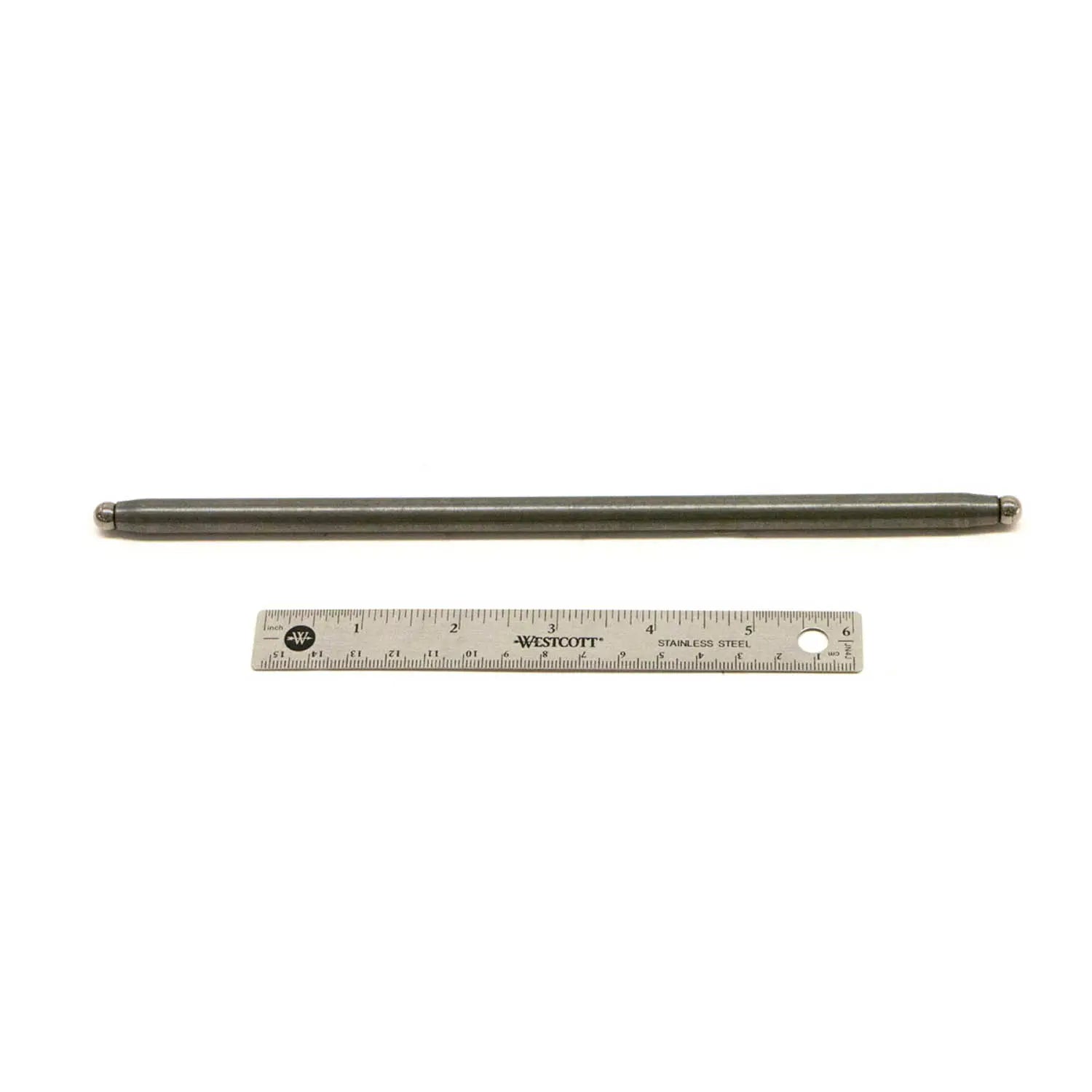 Long slender metallic pushrod with polished finish next to a steel ruler for scale.