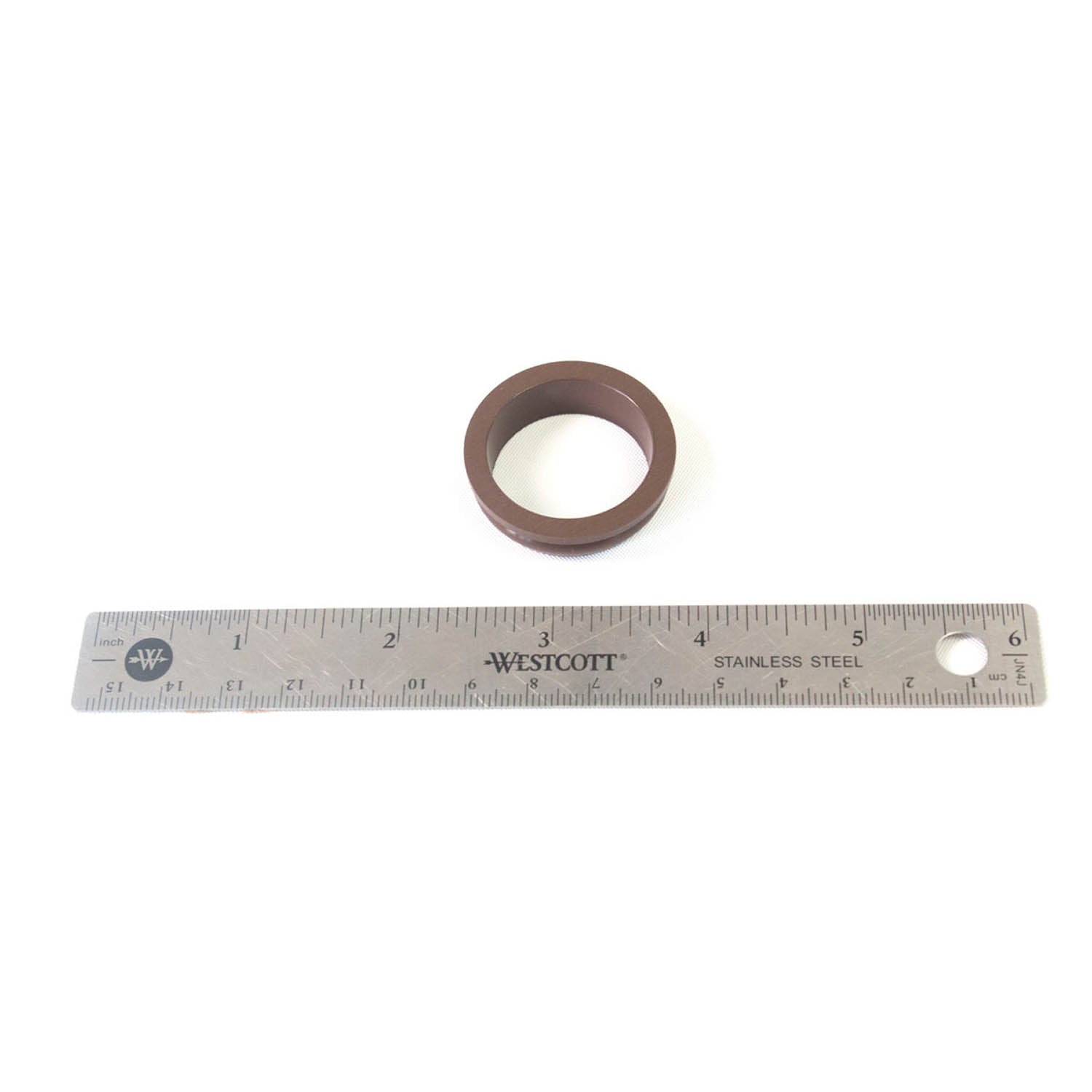 Brown circular rubber pickup seal next to a 12-inch stainless steel ruler.