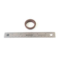 Brown circular rubber pickup seal next to a 12-inch stainless steel ruler.