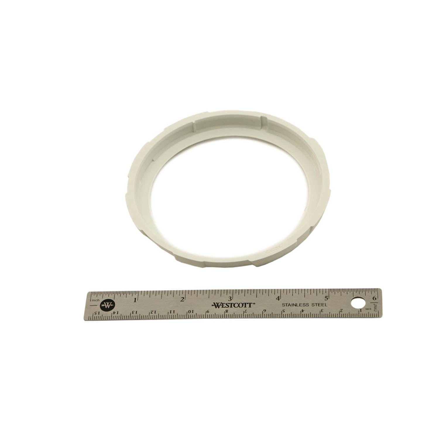 White circular instrument cluster bezel with ridged edges, shown next to a 6-inch ruler for scale.