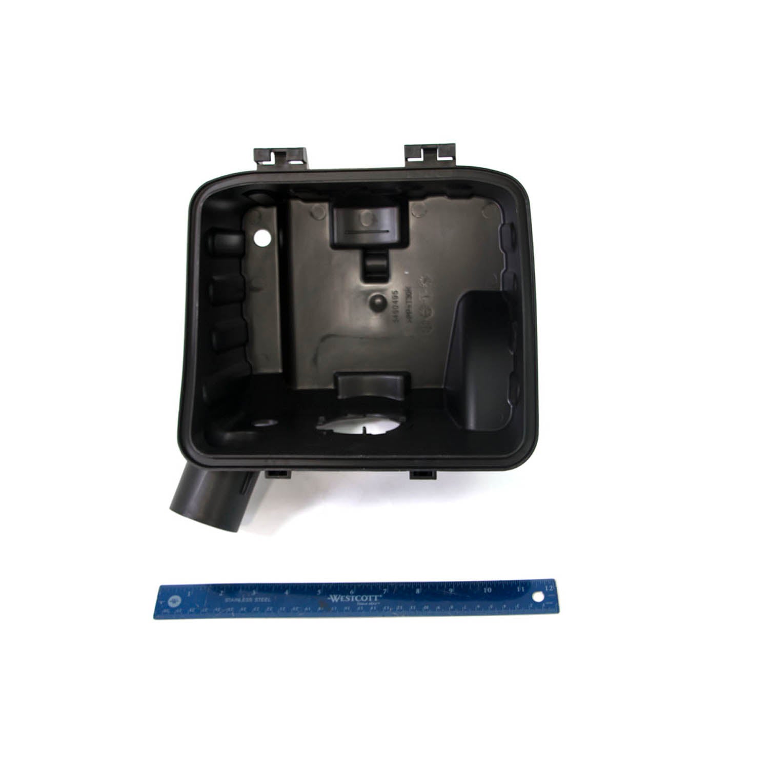 Black rectangular plastic engine intake boot with angled outlet and mounting tabs, shown with blue ruler for scale.