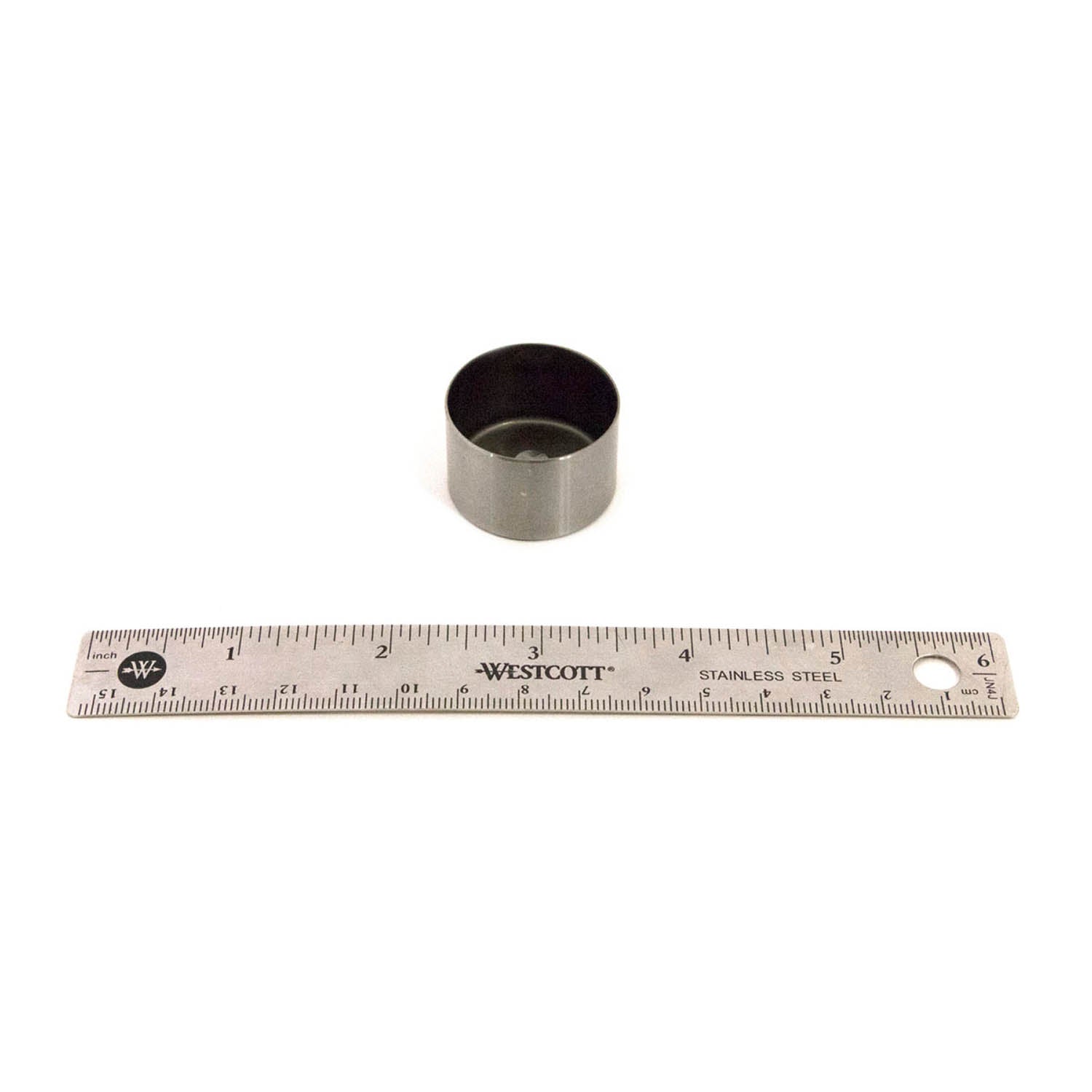Small black cylindrical intake duct seal next to a 6-inch metal ruler on white background.