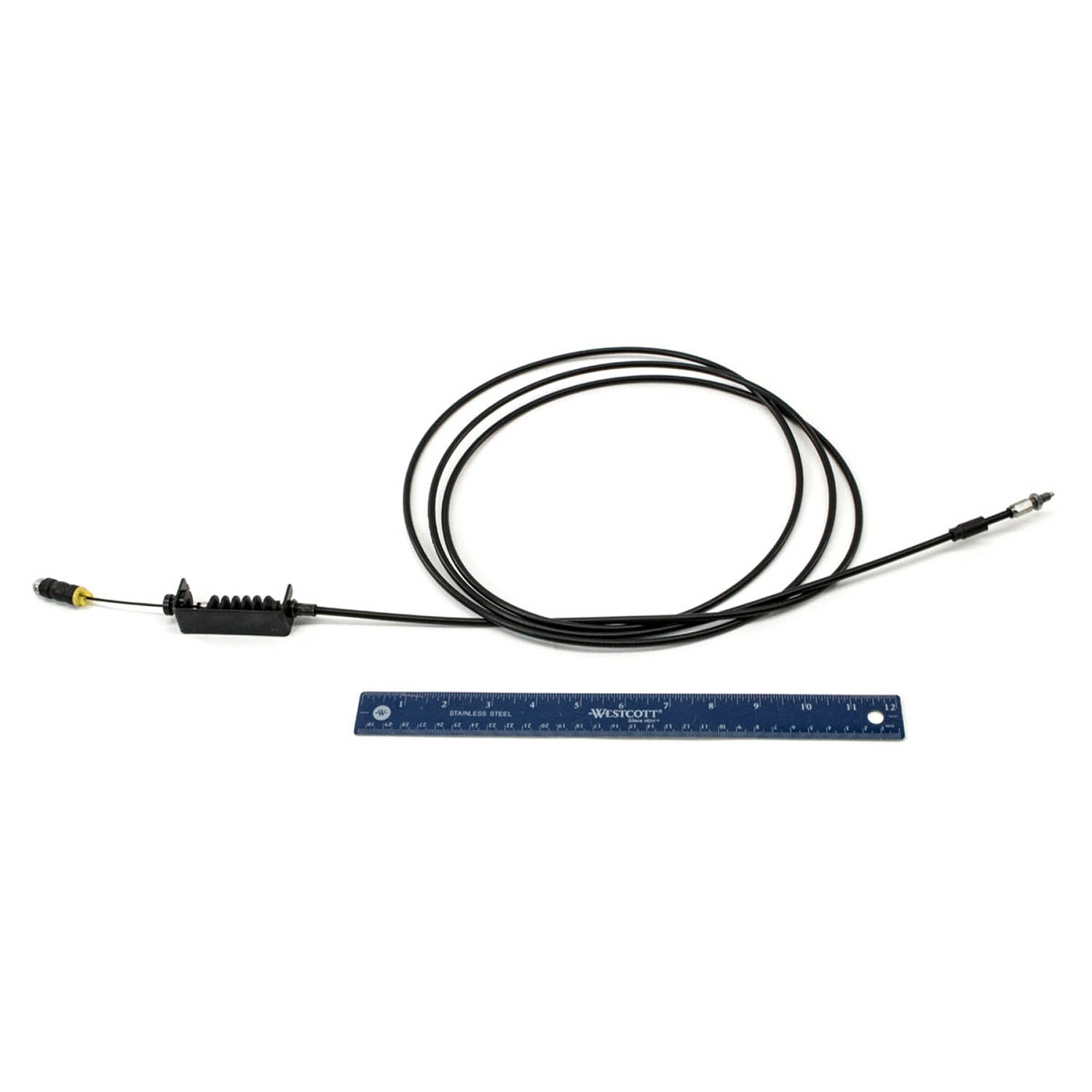 Black flexible throttle cable with metal connectors on both ends, coiled beside a blue ruler for scale.