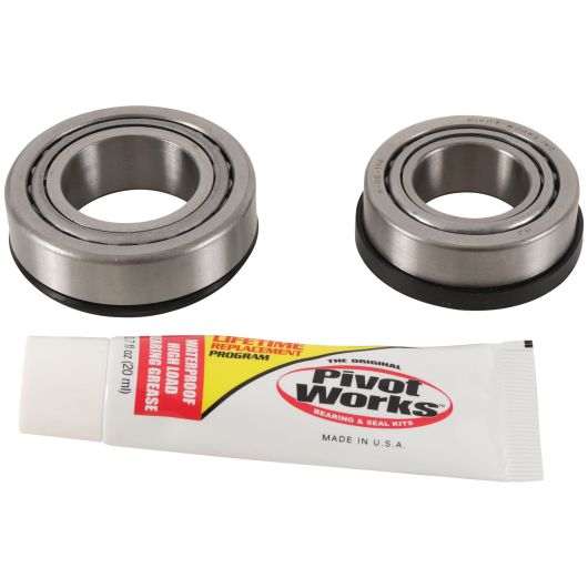 Two silver steel bearings with black seals paired with a white tube of Pivot Works grease lubricant.